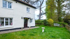 A white house with a front door, windows, and a garden with grass, a bird bath, and a bench. - 2 Bed in Exeter (oc-90455) (Tedburn Saint Mary)