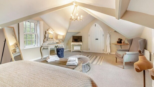 An attic bedroom with a sloped ceiling, a bed, a vanity with a mirror, a desk, a chair, and a wardrobe. - 2 Bed in Consett (oc-90576) (Shotley Low Quarter)