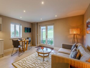 A modern living room with a sofa, a coffee table, and a dining area with chairs and a table. - 1 Bed in Ambleside (oc-90637) (Ambleside)