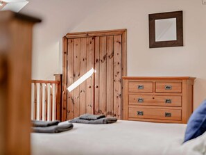 Ein Schlafzimmer mit einem Holzschrank, einem Nachttisch und einem Bett mit Kissen.