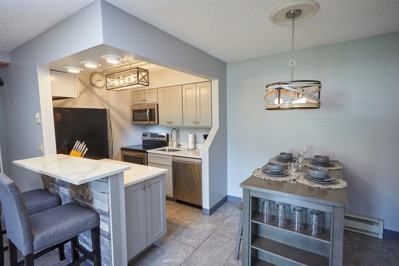 A compact kitchen with a central island, built-in appliances, and a dining area with a table set for two.