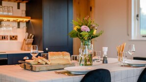 A dining table set with a baguette, wine glasses, and a vase with flowers. - 2 Bed in Leyburn (oc-91102) (Finghall)