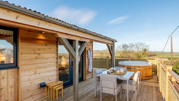 A wooden deck with a hot tub, outdoor seating, and a view of the countryside. - 2 Bed in Leyburn (oc-91102) (Finghall)