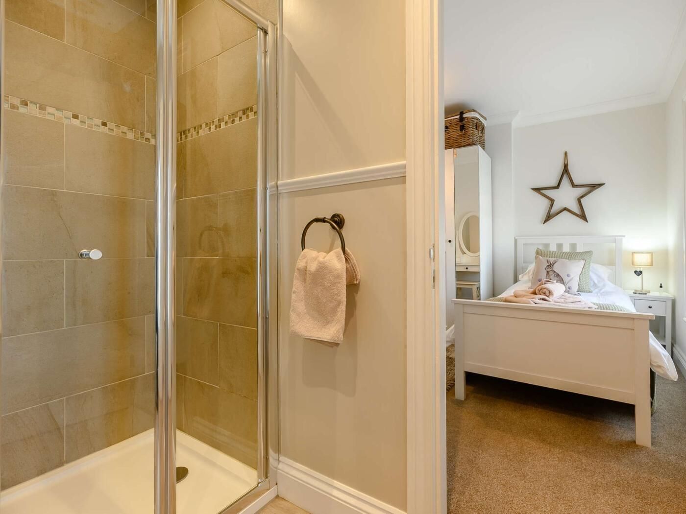 Une salle de bain avec une douche à parois de verre et une serviette accrochée au mur.