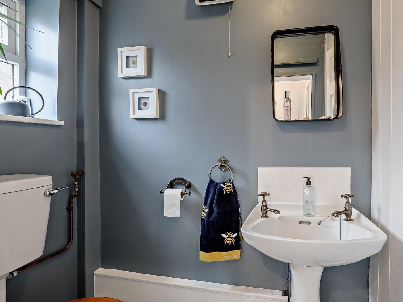 Ein Badezimmer mit einem weißen Waschbecken, einem Spiegel und einem Handtuchhalter mit einem Handtuch.