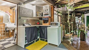 Una cucina compatta con lavandino, forno a microonde e bollitore.