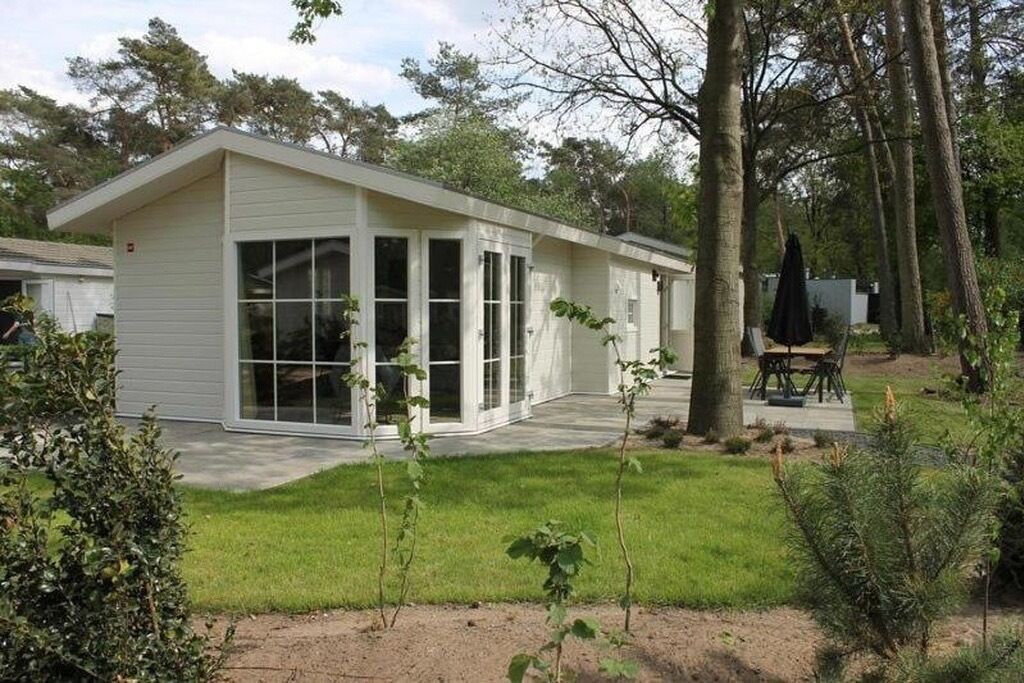 Een laag gebouw met een plat dak, grote ramen en een overdekt terras.