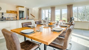 A modern kitchen with a dining area, large windows, and a view of the outdoors. - 5 Bed in Brecon (oc-90660) (Lower Chapel)