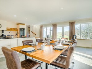 A modern kitchen with a dining area, large windows, and a view of the outdoors. - 5 Bed in Brecon (oc-90660) (Lower Chapel)