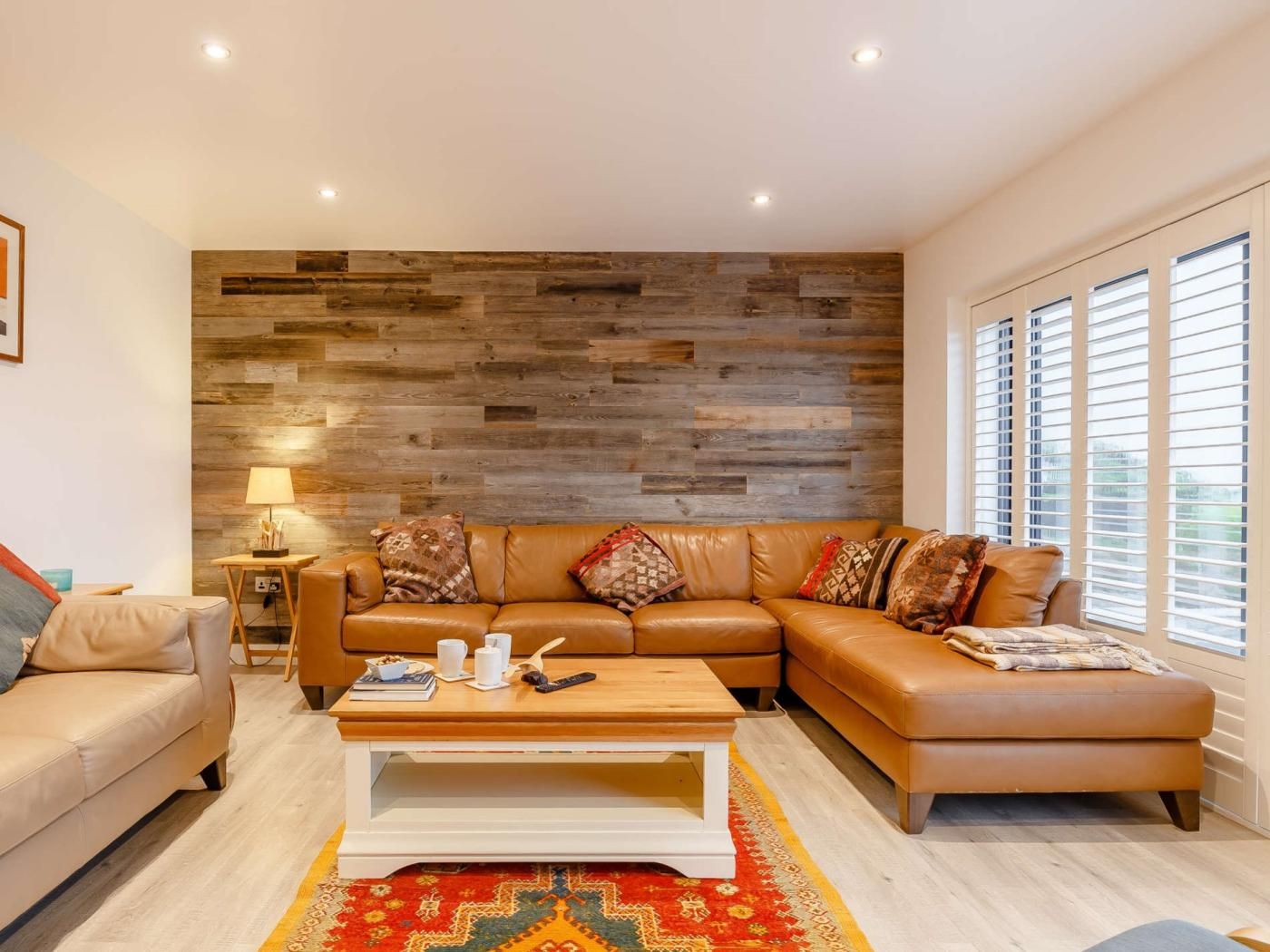 A modern living room with a sectional sofa, a coffee table, and a patterned rug.