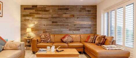 A modern living room with a sectional sofa, a coffee table, and a patterned rug.