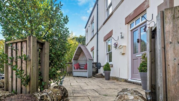 A stone pathway leading to a building with a wooden fence and a stone wall. - 3 Bed in Matlock (oc-90663) (Matlock)