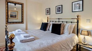 A neatly made bed with white linens, a bedside lamp, and a framed picture above it. - 3 Bed in Matlock (oc-90663) (Matlock)