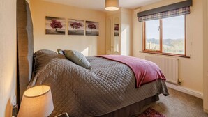 A bedroom with a bed, a window with a view, a radiator, and a lamp. - 1 Bed in Northwich (oc-91266) (Foxwist Green)
