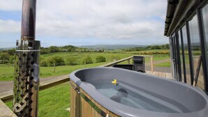 A hot tub on a deck with a view of a green landscape. - 1 Bed in Dalry (oc-91418) (Dalry)
