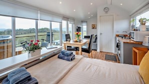 A modern room with a large bed, a dining area, and a kitchen. - 1 Bed in Dalry (oc-91418) (Dalry)