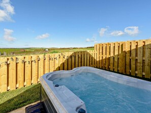 A hot tub with a wooden fence and a view of a green landscape. - 1 Bed in Barnstaple (oc-91387) (Prixford)