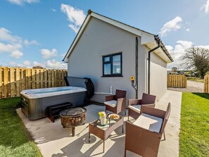 A small, single-story building with a hot tub, outdoor seating, and a fire pit. - 1 Bed in Barnstaple (oc-91387) (Prixford)