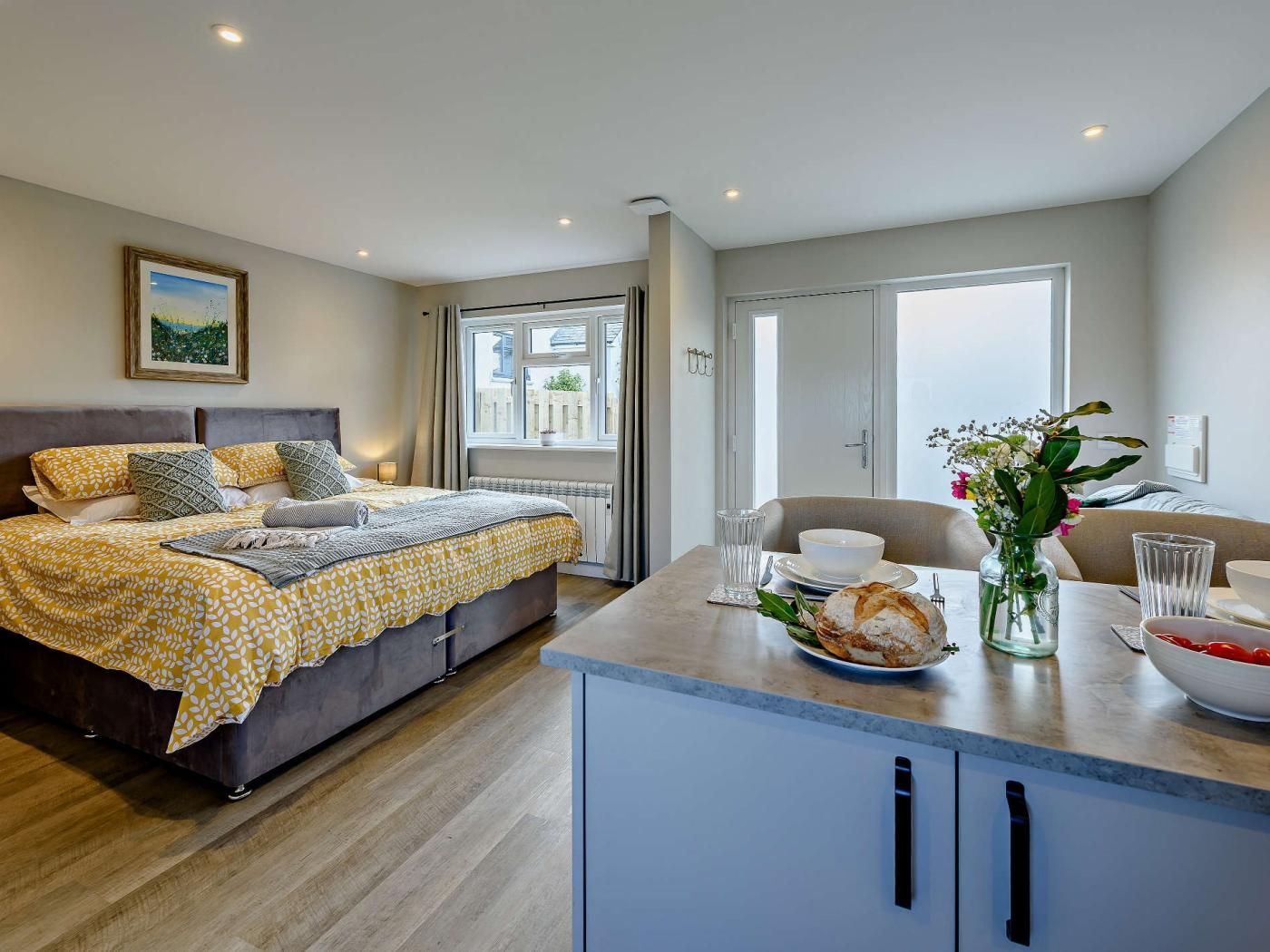 Une chambre à coucher moderne avec un lit, une table de chevet et une fenêtre.