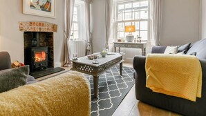 Ein gemütliches Wohnzimmer mit Kamin, einem Esstisch und einer Couch.