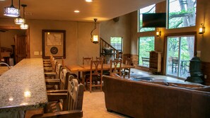 A kitchen with a granite countertop, wooden chairs, a dining table, and a fireplace.