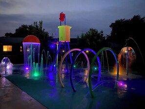 An outdoor water feature with multiple fountains and illuminated structures.