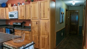 Una cocina con armarios de madera, microondas y estufa.