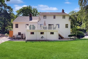 A two-story house with a covered porch, a fenced yard, and a well-maintained lawn.