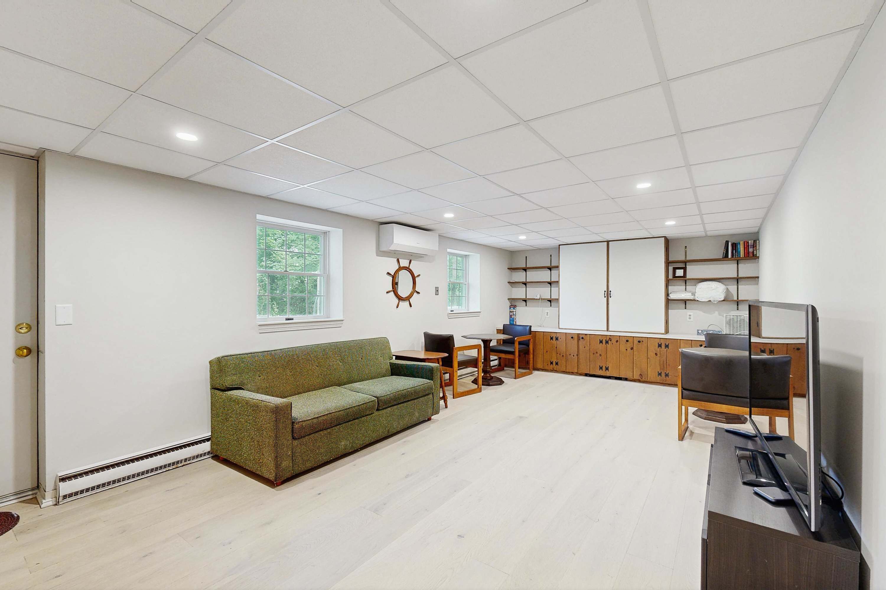Een ruime woonkamer met een bank, een eettafel en een televisie.