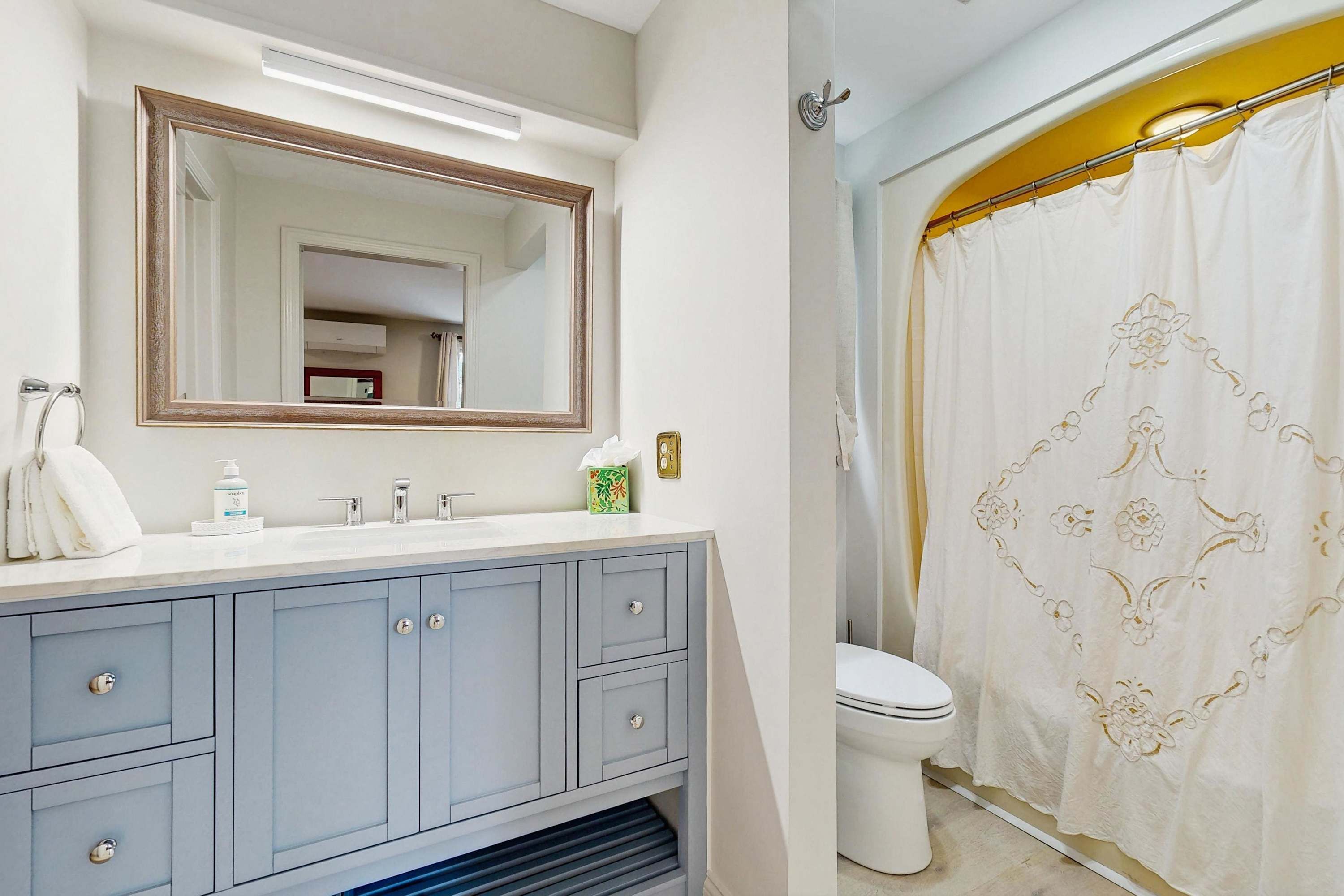 Une salle de bain avec un miroir, un lavabo et des toilettes.