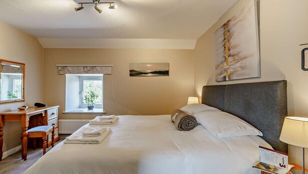 A hotel room with a bed, a desk, a chair, a window with a view, and a painting on the wall. - 3 Bed in Cosheston (oc-90732) (Cosheston)