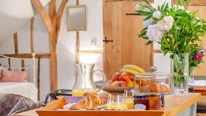 A breakfast buffet with fruits, pastries, and a vase of flowers. - 1 Bed in Billingshurst (oc-90733) (Loxwood)