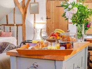 A breakfast buffet with fruits, pastries, and a vase of flowers. - 1 Bed in Billingshurst (oc-90733) (Loxwood)