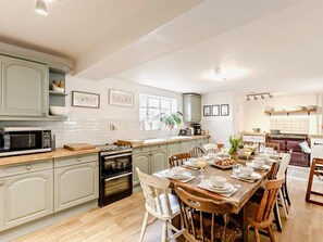 A spacious kitchen with a dining area, featuring a large island, modern appliances, and a view of the outdoors. - 6 Bed in Westbury-on-severn (oc-91045) (Westbury-on-Severn)