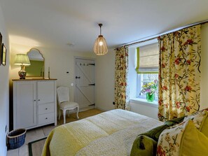 A bedroom with a bed, a dresser, a chair, a hanging light fixture, and a window with curtains. - 1 Bed in Hawick (oc-91437) (Denholm)