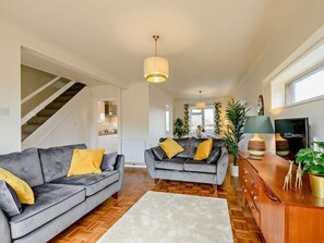 A modern living room with a grey sofa, a wooden coffee table, and a TV. - 3 Bed in Swanage (oc-91451) (Swanage)