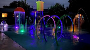 An outdoor water feature with multiple fountains and illuminated structures. - Riverfront Cabins  and  Vacation Homes (Rio Frio)