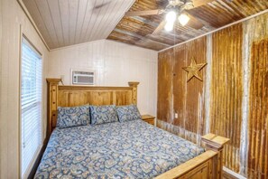 Ein Schlafzimmer mit einem hölzernen Bett, einem Deckenventilator und einer Sternen-Dekoration an der Wand.