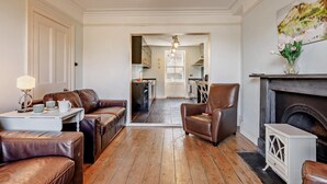 Ein Wohnzimmer mit Kamin, Ledermöbeln und einer Kristallleuchter.