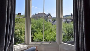 Ein Erker mit Blick auf Grünflächen und Gebäude.