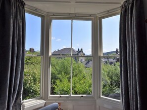 Ein Erker mit Blick auf Grünflächen und Gebäude.
