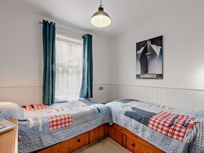 A bedroom with two beds, a window with curtains, a poster on the wall, and a hanging light fixture. - 2 Bed in Alnwick (oc-91486) (Boulmer)