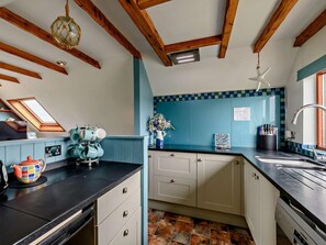 A kitchen with a black countertop, white cabinets, a blue backsplash, and a skylight. - 2 Bed in Alnwick (oc-91486) (Boulmer)
