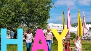 A group of people standing in front of large colorful letters spelling 'HAY.'