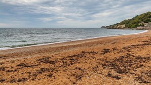A beach with a sandy shore and a view of the sea. - 1 Bed in Ventnor (oc-91536) (Godshill)