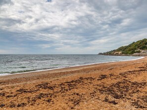Ein Strand mit sandigem Ufer und Blick aufs Meer.