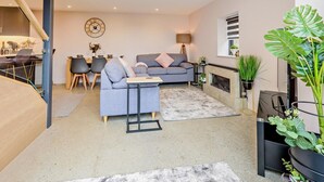 Uma sala de estar moderna com sofá, mesa de centro e área de jantar.