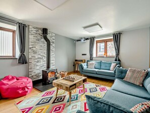 A living room with a fireplace, a sofa, a coffee table, and a bean bag.