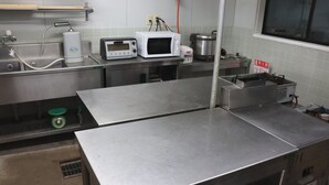 A kitchen with stainless steel countertops, a microwave, a coffee machine, and a sink. - Del Mare Kiami (Masuda)