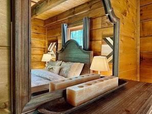 A wooden cabin interior with a bed, two bedside lamps, and a wooden headboard. - Boulder Lodge - The Perfect Mountain Escape in Banner Elk near Winery & Hiking (Banner Elk)
